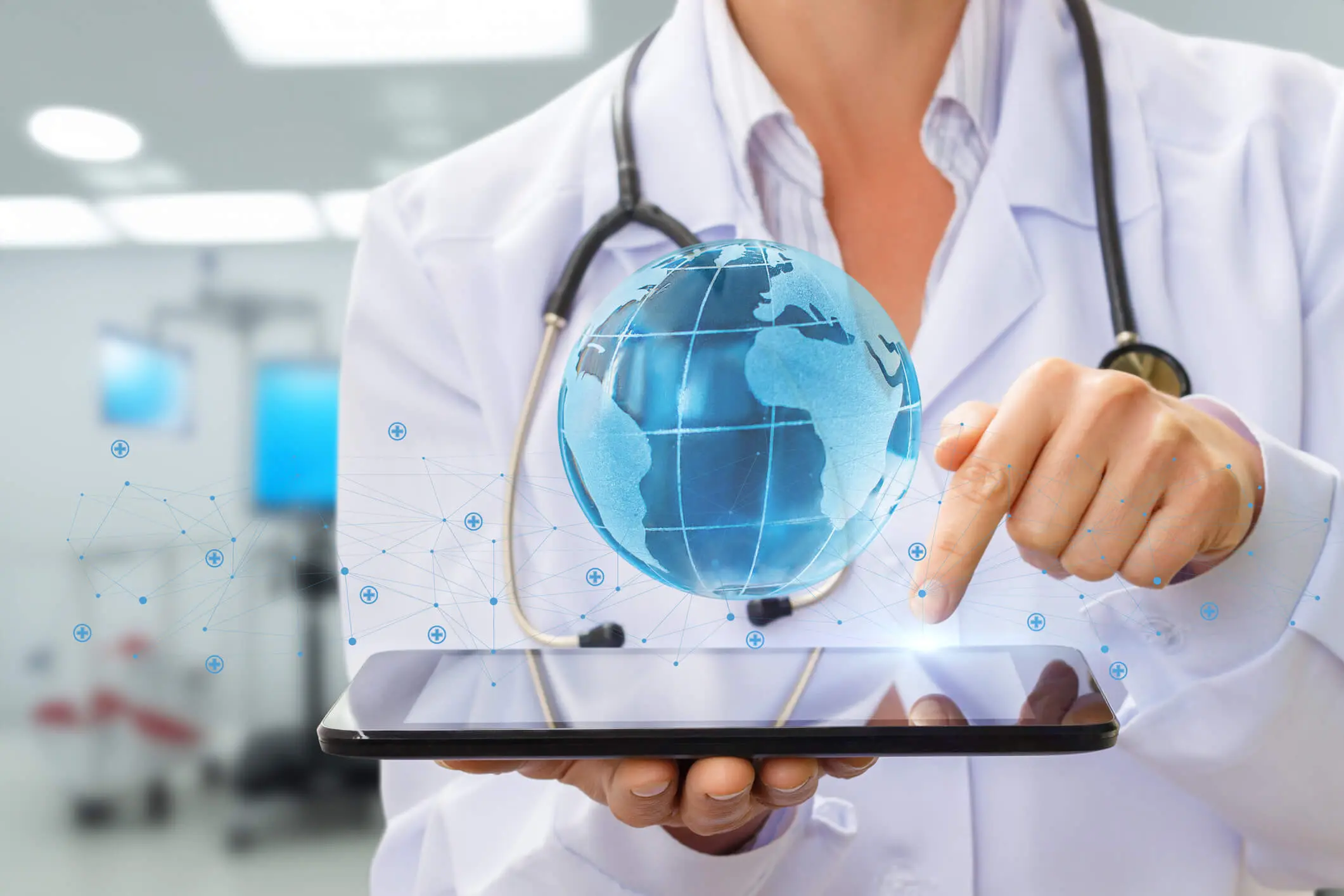 Doctor using tablet with holographic globe.