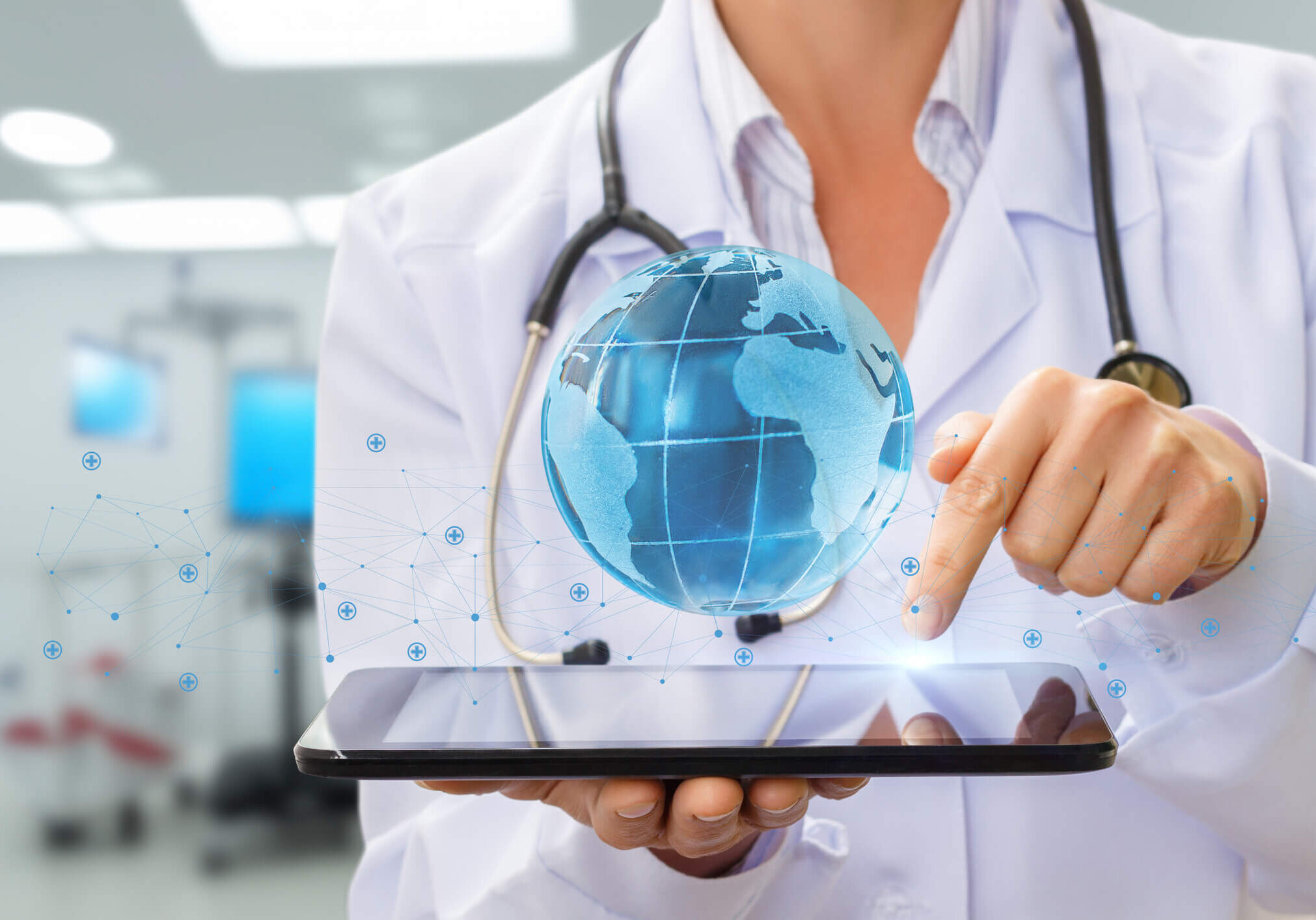 Doctor using tablet with holographic globe.